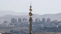 A general view of the mosque of the east Jerusalem neighbourhood of Issawiya and the Israeli West Bank settlement of Maale Adumim in the background, 19 November 2019