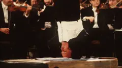 Yehudi Menuhin dirigiendo la Orquesta Filarmónica de Berlín de cabeza en 1982.