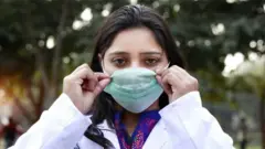 మాస్క్ ధరించిన యువతి