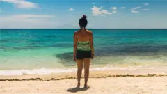 Una mujer frente a la playa