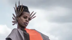 Fashion stylist Wambui Thimba (R) wearing a creation by a Kenyan fashion designer on the rooftop of her apartment in Nairobi, Kenya, on June 1, 2020.