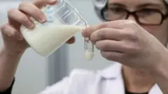 দুধের মান পরীক্ষা করছেন এক গবেষক