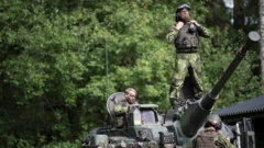 Swedish soldiers man a tank on manoeuvres