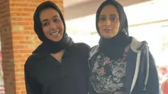 تحريم، إلى اليسار، نظمت الورشة لتعليم الغُسل للشابات المسلمات، تقف إلى جانب إحدى المشاركات في الورشة.