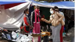 በአዲስ አበባ ጎዳና እየተገበያዩ ያሉ ሰዎች