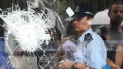 Hong Kong police officer seen through shattered glass