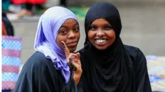 Two young women pose for a photo after performing the Eid prayers at the Masjid Noor Mosque in Nairobi, Kenya