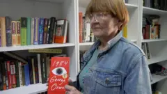 Александра Карасева, Жорж Оруэллнинг "1984" китобини қўлида ушлаб турипти