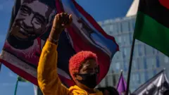 Una mujer afroestadounidense protesta en Los Ángeles con el puño en alto.