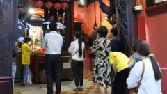 Cầu xin sức khỏe trước tượng Phật dược sư ở chùa Ngọc Hoàng