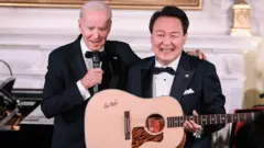 마이크를 잡고 있는 조 바이든 미국 대통령과 기타를 들고 있는 윤석열 한국 대통령