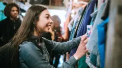 দোকানে পোশাক দেখছে এক নারী