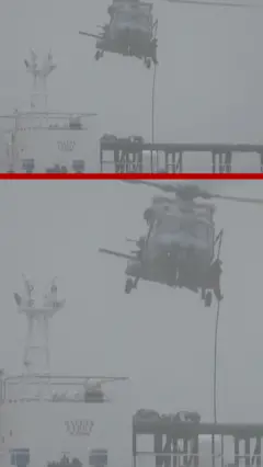 Мужчина спускается с верталена на судно