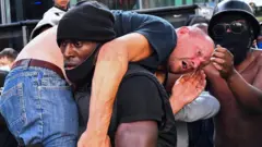 Патрик Хатчинсон выносит из толпы человека