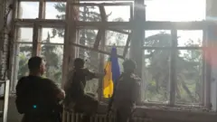 Photo montrant des soldats ukrainiens plaçant un drapeau national ukrainien sur un bâtiment détruit dans le village de Blahodatne, dans l'est de l'Ukraine. Photo : 11 juin 2023
