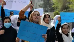 Afghan women and girls take part in a protest in front of the Ministry of Education in Kabul on March 26, 2022