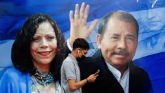 A man checks his phone while walking by a banner promoting Nicaraguan President Daniel Ortega and Vice President Rosario Murillo as presidential election campaigning begins, in Managua, Nicaragua, September 25, 2021
