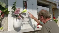 የመቃብር ቦታ የሚጎበኝ ግለሰብ