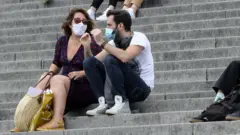 People sit outside the Sacre-Couer in Paris