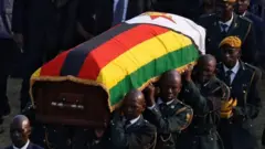 Isanduku irimo umurambo wa Robert Mugabe ubwo yari ijyanwe kuri kajugujugu ya gisirikare nyuma yo gusezerwaho ku itariki ya 13 y'uku kwezi kwa cyenda