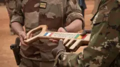 Le colonel français Faivre remet la clé symbolique du camp Barkhane au colonel malien lors de la cérémonie de remise de la base militaire de Barkhane à l'armée malienne à Tombouctou, le 14 décembre 2021.