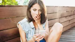 Joven leyendo un comentario en su celular