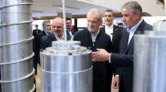 مسعود پزشکیان رئیس جمهور ایران در کنار محمد اسلامی، رئیس سازمان انرژی اتمی ایران (نفر اول از سمت راست) در بازدید از نمایشگاه «دستاوردهای هسته‌ای» در فروردین امسال