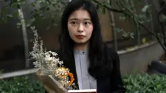 Zhou Xiaoxuan, also known by her online name Xianzi, speaks to supporters as she arrives at a court for a sexual harassment case involving a Chinese state TV host, in Beijing, China on 14 September 2021