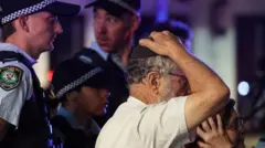 A man holds his head surrounded by police at the scene of a shooting on Bondi beach.