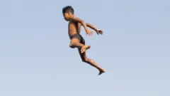 Children jump into the water of the Nile.