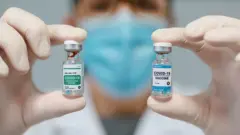 Médica mostrando dos opciones de vacuna contra el coronavirus
