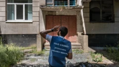 A Kharkiv regional prosecutor inspects shell damage at an agricultural college near the city. Prosecutors have had to learn quickly how to conduct war crimes investigations.