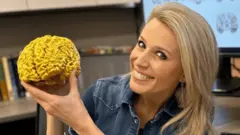 Би-би-си мухбири Лара Люингтон 3D принтерида чиқарилган ўз миясининг ҳақиқий катталигидаги нусхаси билан