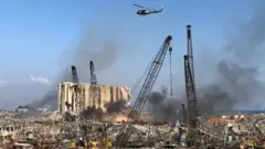 A Lebanese army helicopter flies over the site of Tuesday's blast in Beirut's port area, Lebanon August 5, 2020
