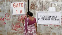 Mulher, que vinha receber vacina contra coronavírus (COVID-19), fica em frente ao portão fechado de um posto de vacinação que foi fechado por indisponibilidade de fornecimento da vacina COVID-19, em Mumbai, Índia , 3 de maio de 2021.