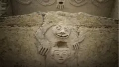Una foto de la zona arqueológica de Caral que muestra la figura de una rana antropomórfica descubierta en una de las edificaciones de la civilización Caral, al norte de Lima.