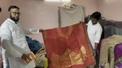 आलिम अंसारी कपड़ा दिखाते हुए