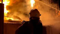 A firefighter works to extinguish a fire at a power infrastructure object on 6 December
