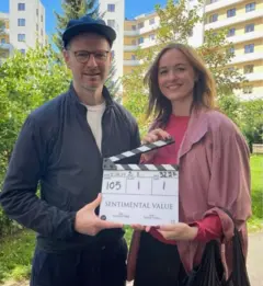 O diretor Joachim Trier e a atriz Renate Reinsve segurando uma claquete com o nome do filme "Sentimental Value"