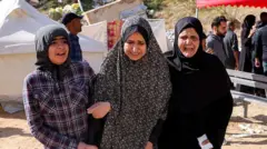 İsrail'in Cebaliye bombardımanında hayatını kaybedenlerin yasını tutan kadınlar birbirlerine sarılmış şekilde yürüyor