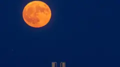 يرتفع القمر الأزرق العملاق خلف معبد بوسيدون القديم في كيب سونيون، جنوب أثينا، اليونان، في 19 أغسطس/آب 2024