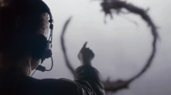 Человек в наушниках указывает на непонятную кольцеобразную структуру впереди — эта деталь фото не в фокусе, а потому выглядит довольно размытой