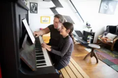 Criança aprendendo a tocar piano