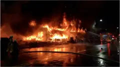 Firefighters using water cannon to extinguish a fire on a commercial and residential building in Kaohsiung city, southern Taiwan, 14 October 2021