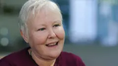 Jay Evans, a woman with short grey hair, smiles at the camera