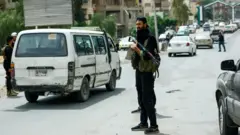 Suriye sokaklarında asayiş sağlayan silahlı adamlar 