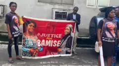 Aworan awọn obinrin meji ti wọn gbe asia to n beere idajọ ododo fun Bamise