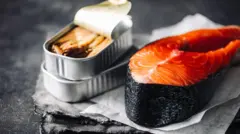 Lata de sardinhas ao lado de um filé de salmão