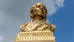Busto en color oro de Miguel Hidalgo.