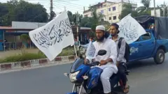 মাদারীপুরে কালেমা খচিত পতাকা নিয়ে মিছিলে যাচ্ছেন দুই যুবক